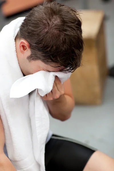 Harrassed athletic man standing with a towel — Stock Photo, Image