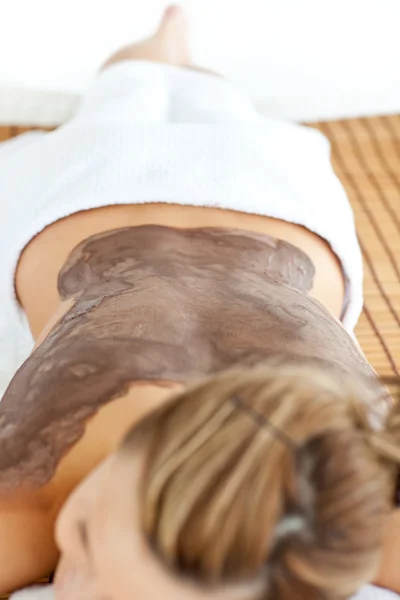Giovane donna caucasica sdraiata su un tavolo da massaggio con fango sul suo b — Foto Stock