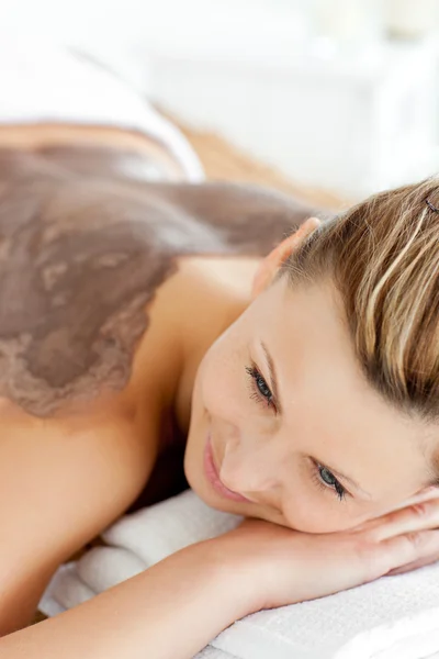 Retrato de una mujer acostada sobre una mesa de masaje con barro en su bac —  Fotos de Stock