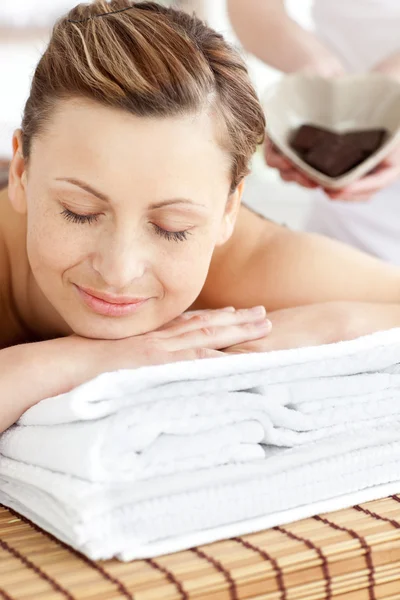Smiling caucasian woman lying on a massage table in a spa center — Stock Photo, Image