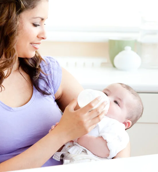 Mãe radiante alimentando seu filho adorável na cozinha — Fotografia de Stock