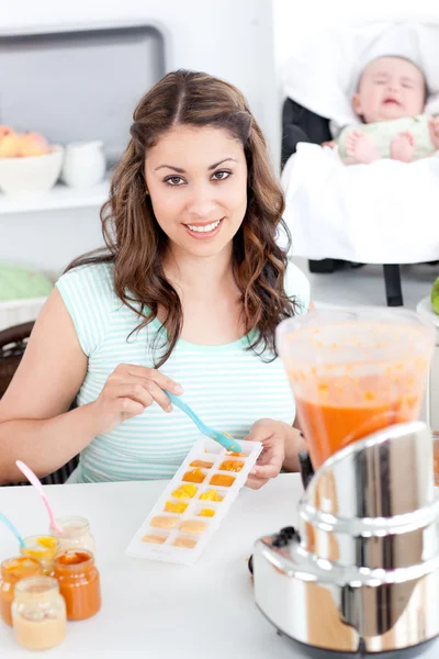 Opieka matki przygotowywania potraw dla jej piękne dziecko w kuchni — Zdjęcie stockowe