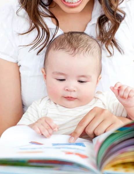 Mãe brilhante mostrando imagens em um livro para seu filho pequeno bonito — Fotografia de Stock