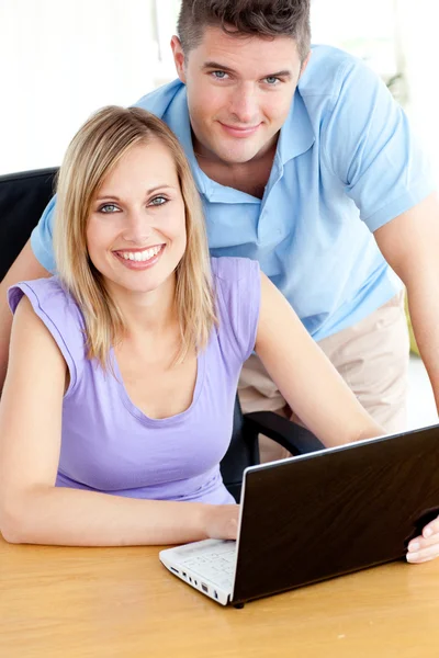 Couple joyeux utilisant un ordinateur portable assis dans la cuisine — Photo