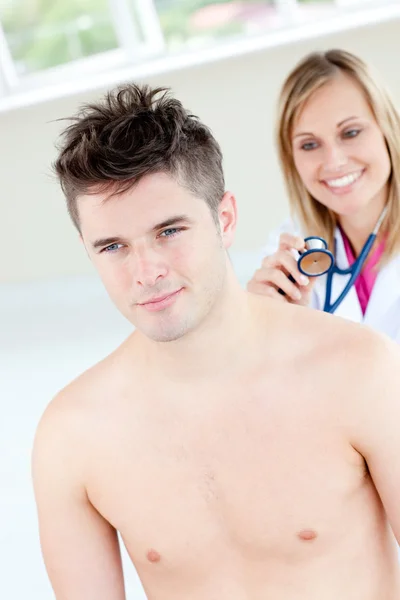 Sorrindo médico feminino soando seu paciente masculino — Fotografia de Stock