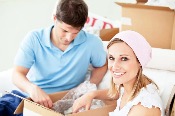 Ambitious young couple unpacking boxes with glasses — Stock Photo, Image