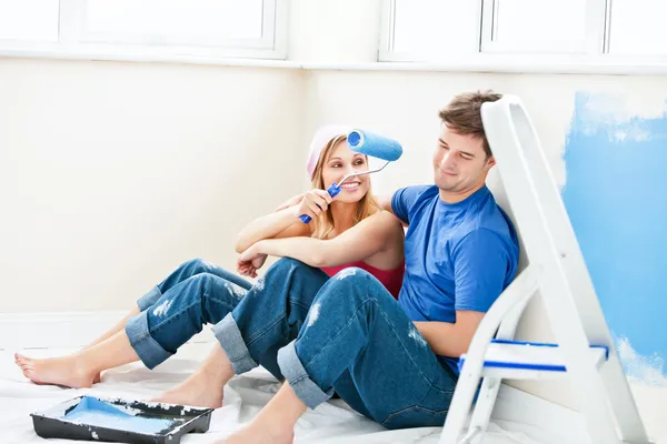 Charming couple relaxing after painting a room — Stock Photo, Image