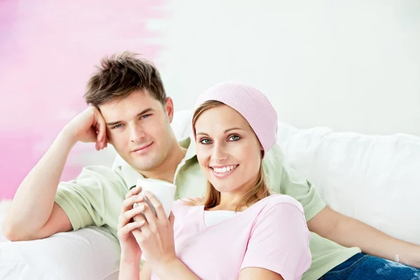 Relaxing couple lying on a sofa after painting a room — Stock Photo, Image