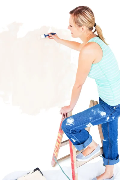 Mujer joven animada pintando una habitación — Foto de Stock