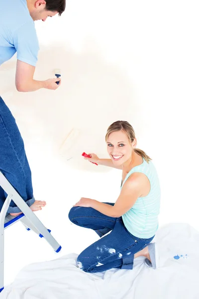 Sério casal caucasiano pintando um quarto — Fotografia de Stock