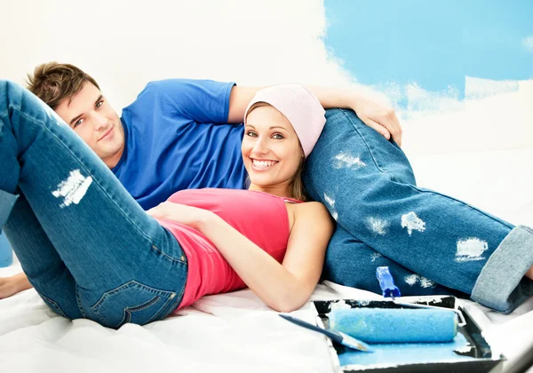 Щаслива молода пара розслабляється після фарбування кімнати — стокове фото