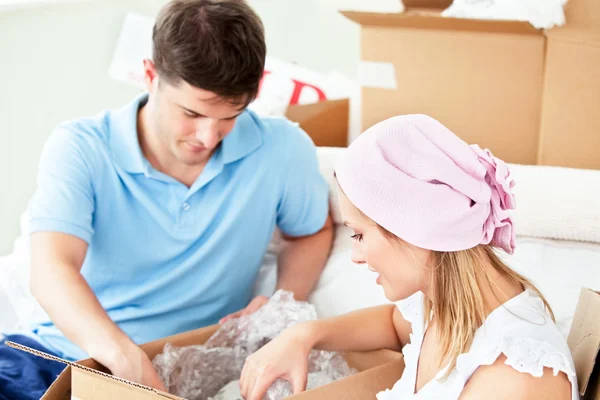 Serious caucasian couple unpacking boxes with glasses — Stock Photo, Image