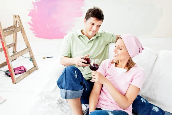 Glad kaukasisk par liggande på en soffa och dricker vin aft — Stockfoto