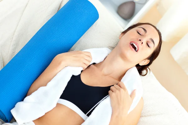 Mulher exausta sentada em um sofá depois de exercitar-se em sua vida — Fotografia de Stock