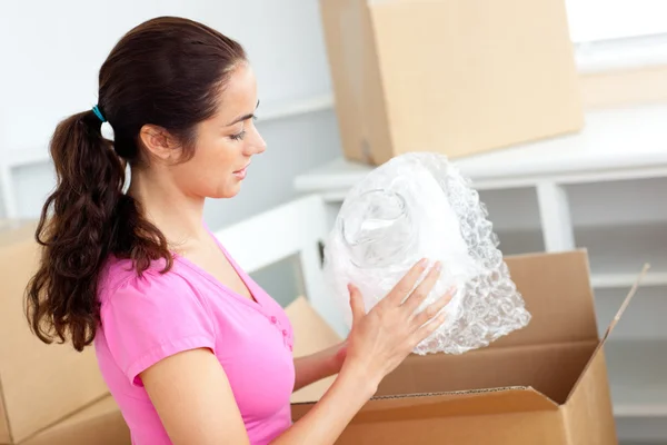 Mulher branca jovem desempacotando caixas com óculos — Fotografia de Stock