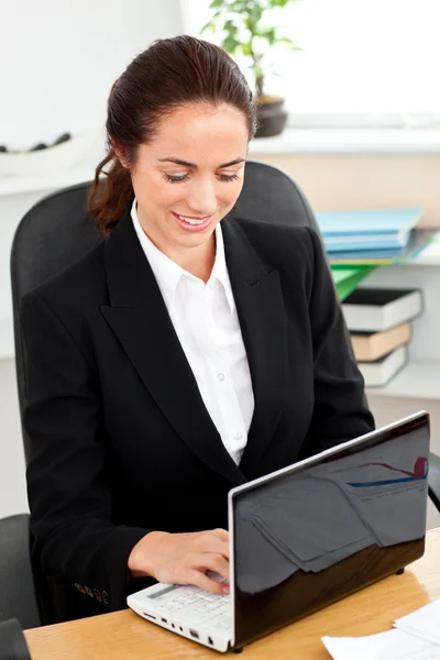 Charismatische jonge zakenvrouw met behulp van haar laptop zit op haar — Stockfoto