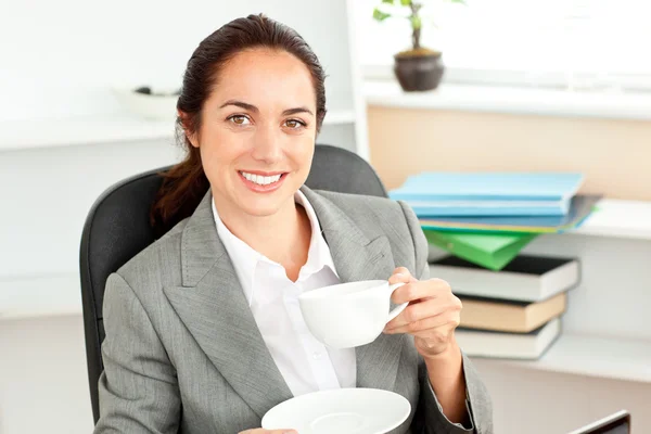 Felice donna d'affari in possesso di una tazza di caffè seduto nella sua offic — Foto Stock