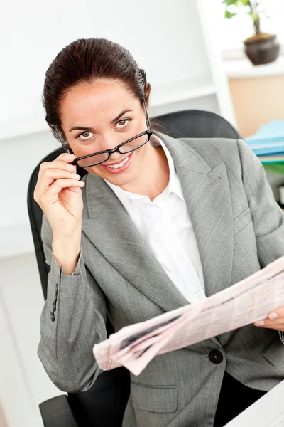 Mulher de negócios brilhante segurando óculos e jornal olhando para th — Fotografia de Stock