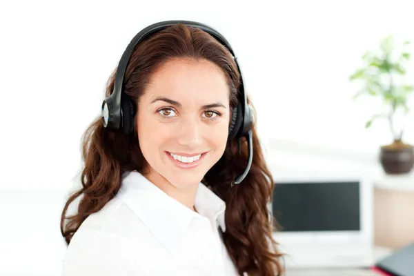 Mulher encantadora com fone de ouvido trabalhando em um call center — Fotografia de Stock
