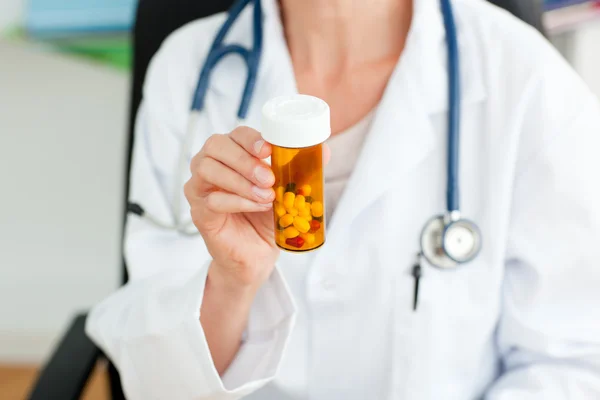 Close-up de um médico feminino segurando pílulas na câmera — Fotografia de Stock