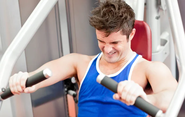 Strong athletic man using a bench press — Stock Photo, Image