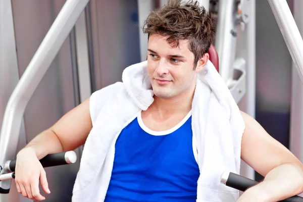 Cute relaxed man with a towel using a bench press — Stock Photo, Image