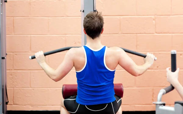 Atleta masculino carismático praticando musculação — Fotografia de Stock