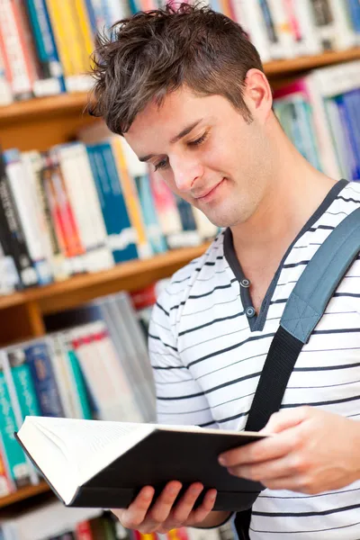 Söt manlig student som läser en bok — Stockfoto