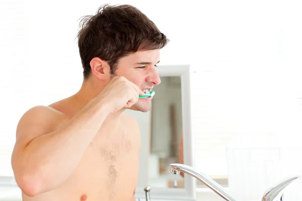 Όμορφος νεαρός άνδρας, βουρτσίζετε τα δόντια του στο μπάνιο — Φωτογραφία Αρχείου