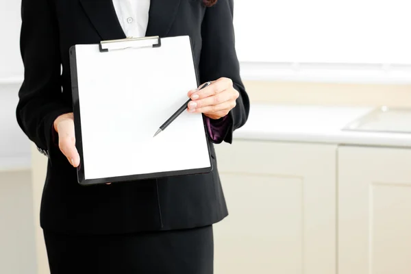 Close-up of a businesswoman holding a clipboard and a pen — Stock Photo, Image