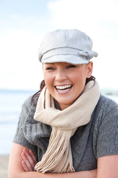 Donna caucasica ridente con cappello e sciarpa in piedi sulla spiaggia — Foto Stock