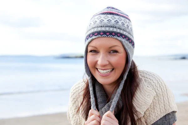 Bella donna con sciarpa e cappello colorato in piedi sulla spiaggia — Foto Stock