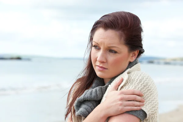 Mujer infeliz vistiendo suéter en la playa y haciendo frío — Foto de Stock