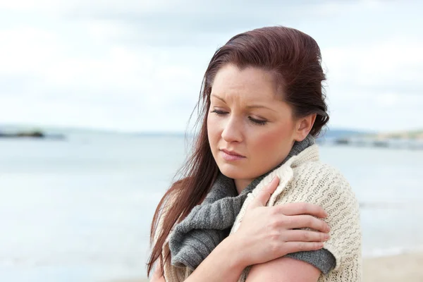 Mujer infeliz vistiendo suéter en la playa y haciendo frío —  Fotos de Stock