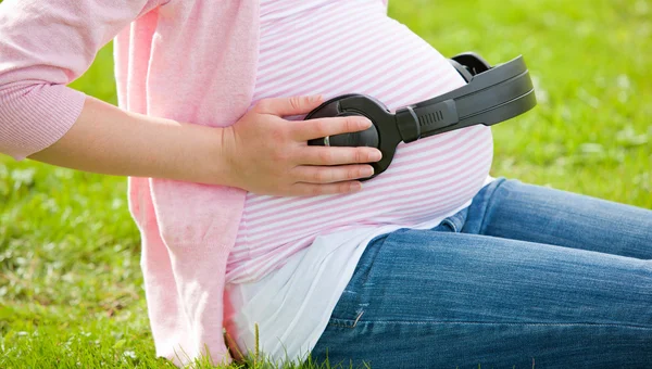 Örömteli terhes nő hasára fejhallgató — Stock Fotó