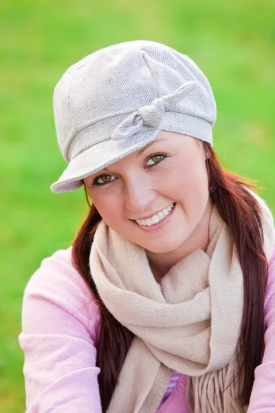 Joyeux jeune femme portant casquette et écharpe souriant à la caméra — Photo
