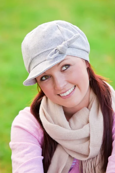 Mujer joven y feliz con gorra y bufanda sonriendo a la cámara —  Fotos de Stock
