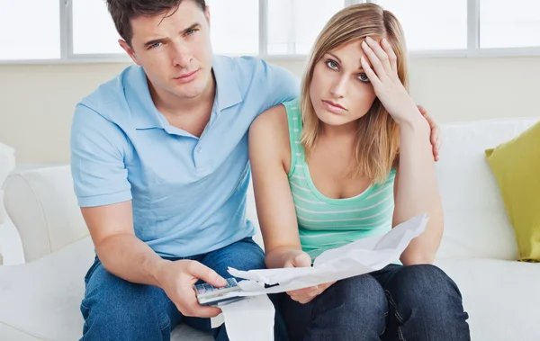 Besorgtes Paar nach Rechnungen im Wohnzimmer — Stockfoto