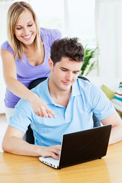 Atraktivní žena ukazovat něco, co v počítači na jeho boyfri. — Stock fotografie