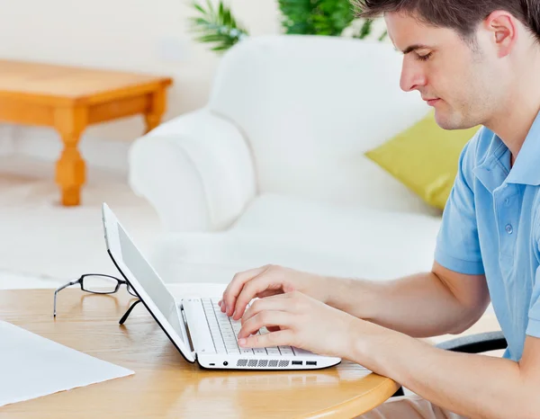 Focused handsome man working on his laptop sitting in the living — Stock Photo, Image