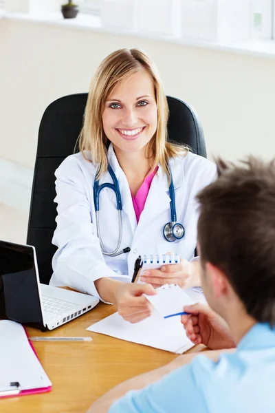 Radostné ženský lékař dává předpis svého pacienta v — Stock fotografie