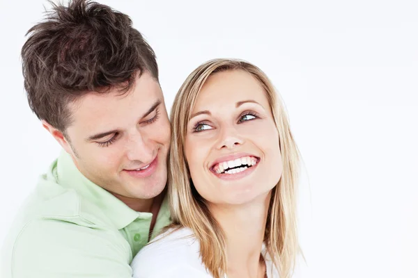 Bonito homem abraçando sua namorada rindo contra um bac branco — Fotografia de Stock