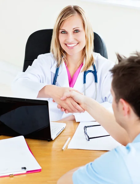 Uśmiechający się drżenie rąk jej pacjenta lekarz — Zdjęcie stockowe