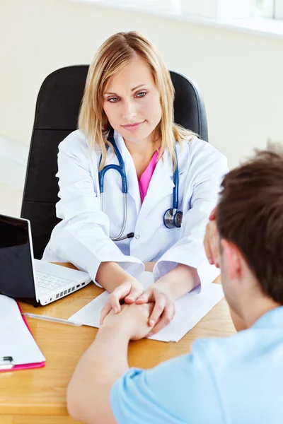 Aantrekkelijke vrouwelijke arts opknoping van de hand van haar mannelijke patiënt — Stockfoto
