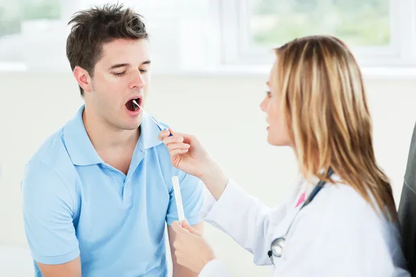 Médica a extrair saliva — Fotografia de Stock