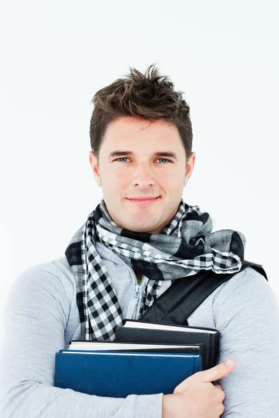 Молодий чоловік у шарфі стискає книги проти себе — стокове фото