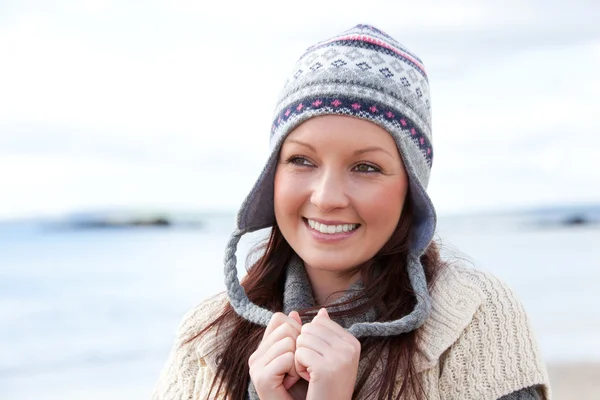 微笑着的年轻女子在沙滩上戴一顶帽子 — 图库照片