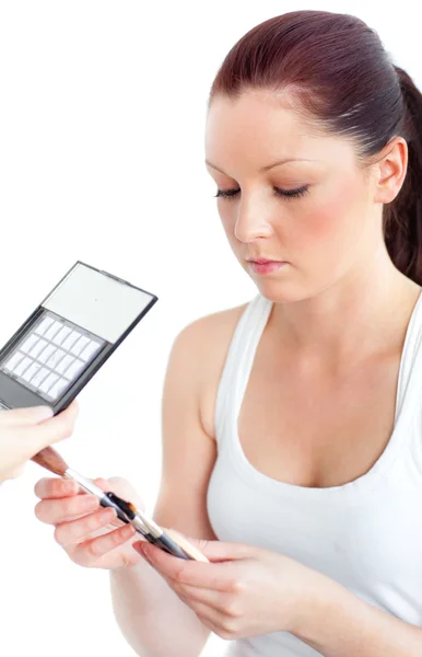 Beautiful woman putting powder on her face over white backgroung — Stock Photo, Image