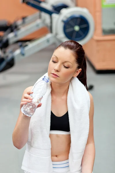 Niedliche athletische Frau trinkt Wasser nach Übungen in einem Fitness-Studio — Stockfoto