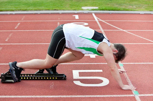 Αθλητική άνθρωπος στη γραμμή εκκίνησης, βάζοντας το πόδι του σε το starti — Φωτογραφία Αρχείου